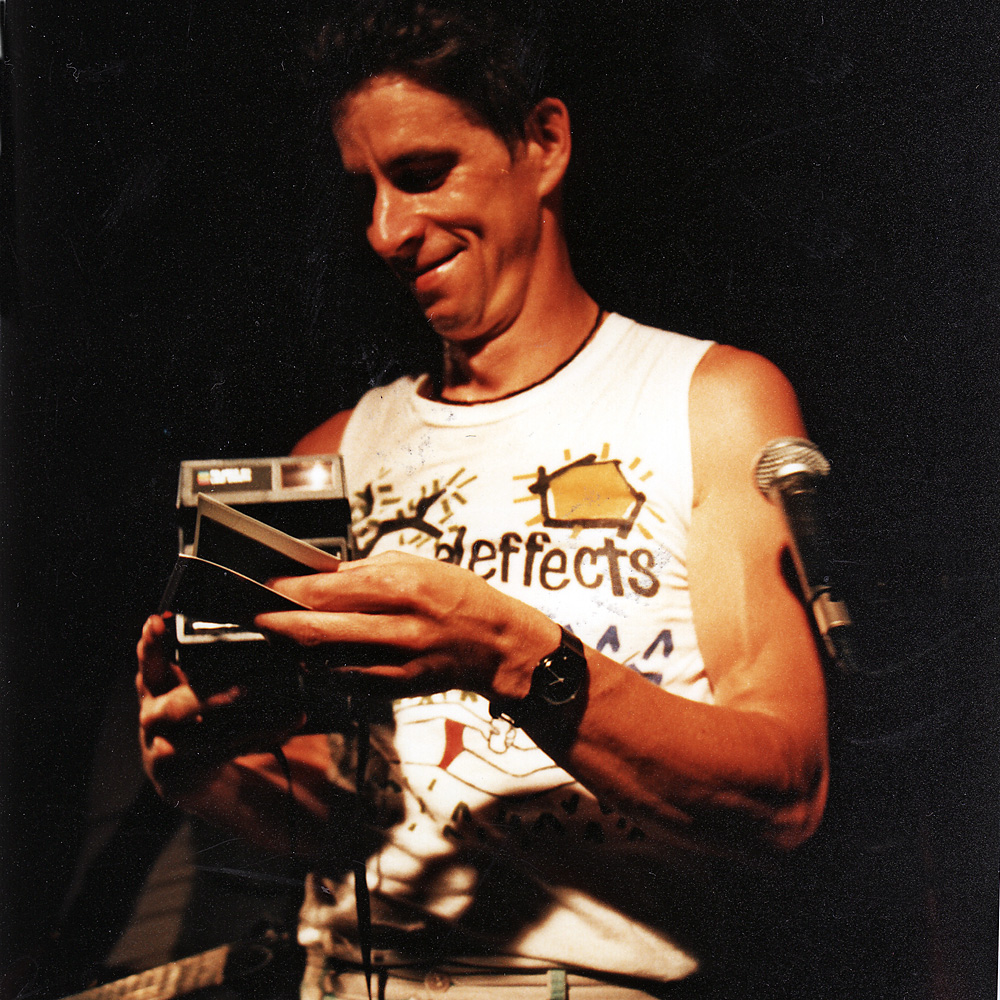 Paul Dodd with Poloroid camera, taking pictures from the stage at Scorgies in Rochester, New York.