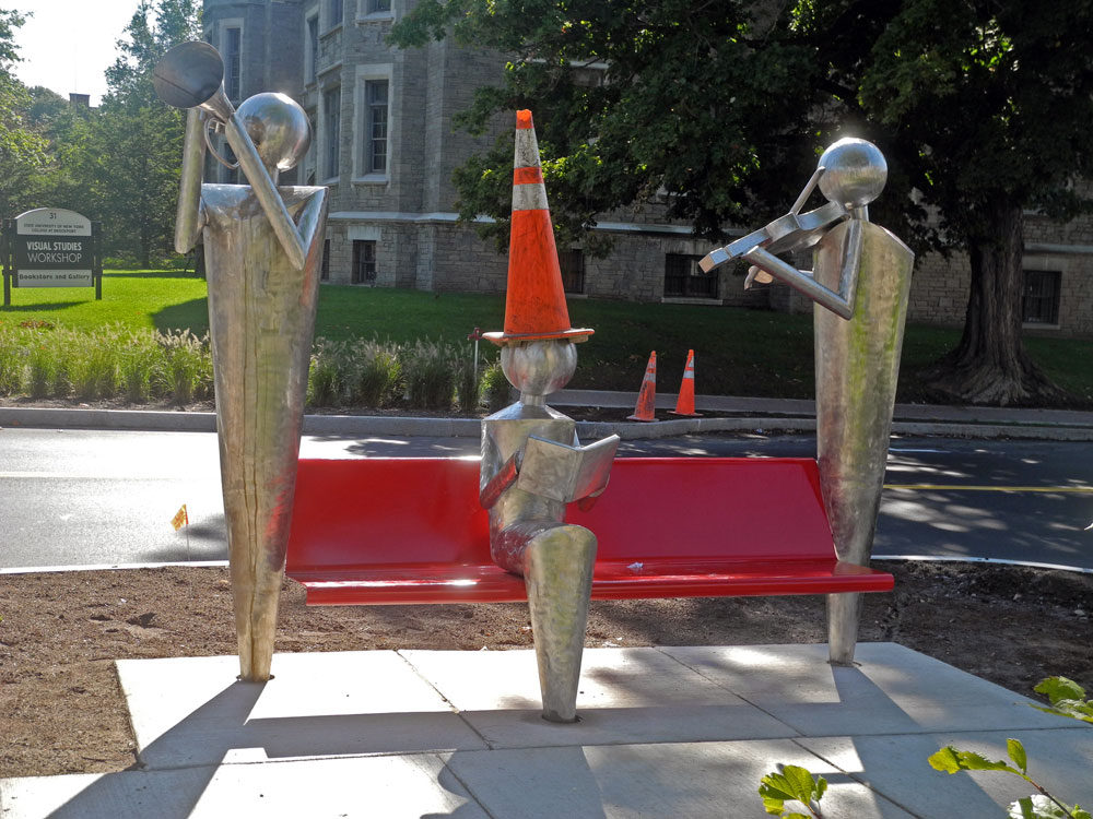 Bench with orange safety cone in front of School of the Arts