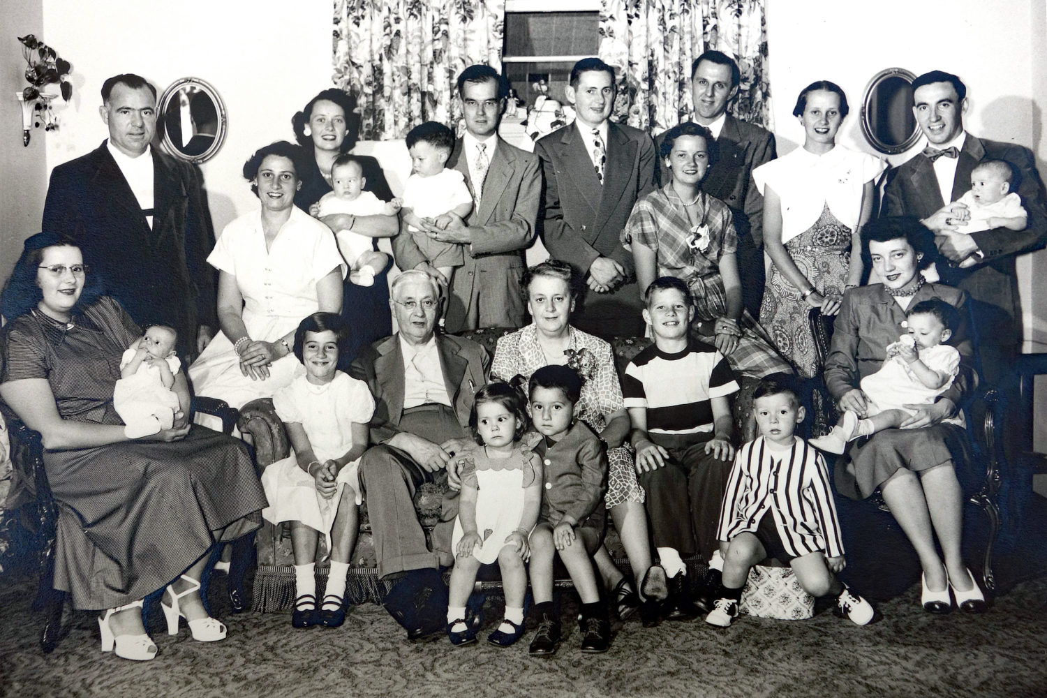 Back row, left to right: Jerry Austin, Rita (Tierney) Austin, Isabel (Tierney)Williams with Greg Williams in her arms, Jack Williams with Chris Williams in his arms, Ray Tierney Jr, Ann Tierney, Ed Kolb, Mary (Tierney) Dodd, Leo Dodd with Paul Dodd in his arms, Front row: Martha (Tierney) Kolb with Nancy Kolb in her arms, Mary Austin, Ray Tierney Sr., Mary (Maime) Tierney with Kathleen Kolb and Jim Austin sitting in front of her, Dick Austin, Ray Tierney III, Rita (Ritzenthaler) Tierney with Debby Tierney in her arms.