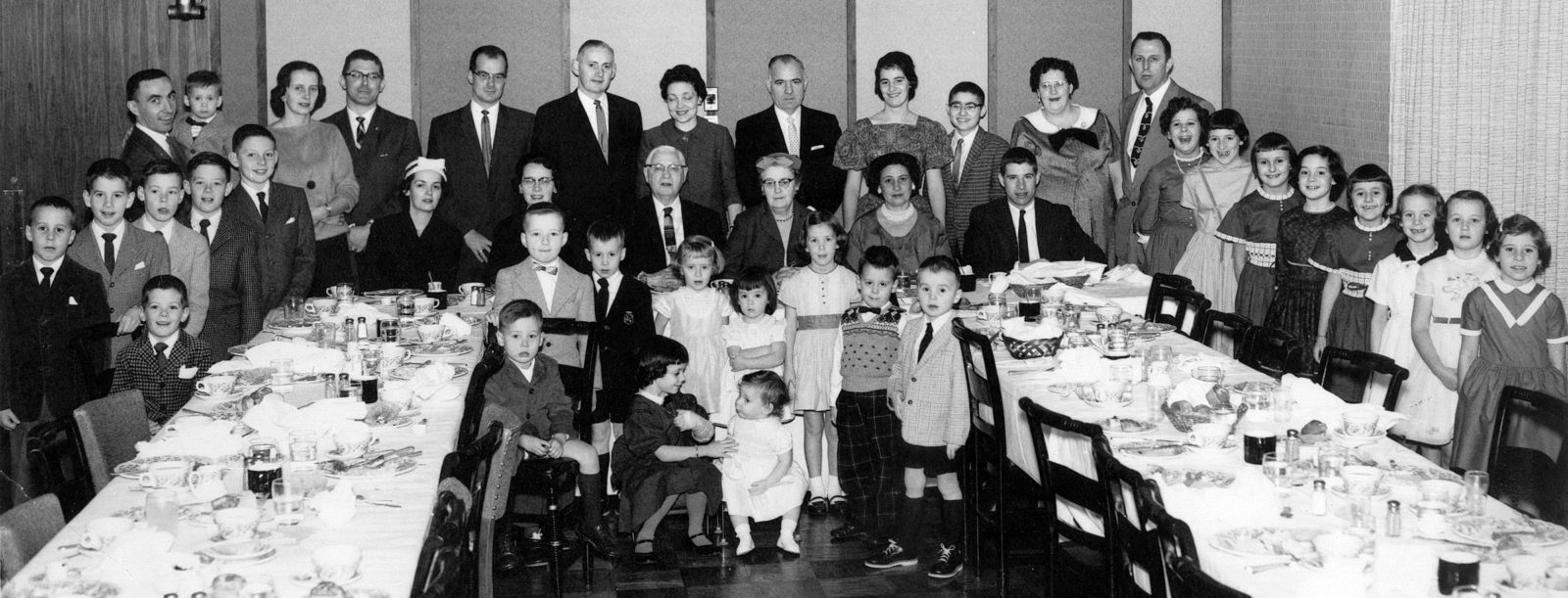 Standing, left to right: Mark Dodd, Paul Dodd, Greg Williams, Chris Williams, Ray Tierney, Leo Dodd with Fran Dodd in his arms, Mary (Tierney) Dodd, Bob Oliver, Jack Williams, Ray Tierney Jr., Rita (Ritzenthaler) Tierney, Jerry Austin, Mary Austin, Jim Austin, Martha (Tierney) Kolb, Ed Kolb, Kathleen Kolb, Debby Tierney, Nancy Kolb, Patty Tierney, Janet Kolb, Ann Dodd, Ann Williams, Theresa Austin. Seated: Far left, John Oliver, Ann (Tierney) Oliver, Isabel (Tierney) Williams, Ray Tierney Sr., Mary (Maime) Tierney, Rita (Tierney) Austin, Dick Austin. Between the tables, back row: Jim Williams, John Dodd, Mary Williams, Mary Ann Oliver, Catherine Oliver, Gerard Kolb, Tim Dodd. Front row: Tom Williams, Liz Tierney, Rosemary Tierney.