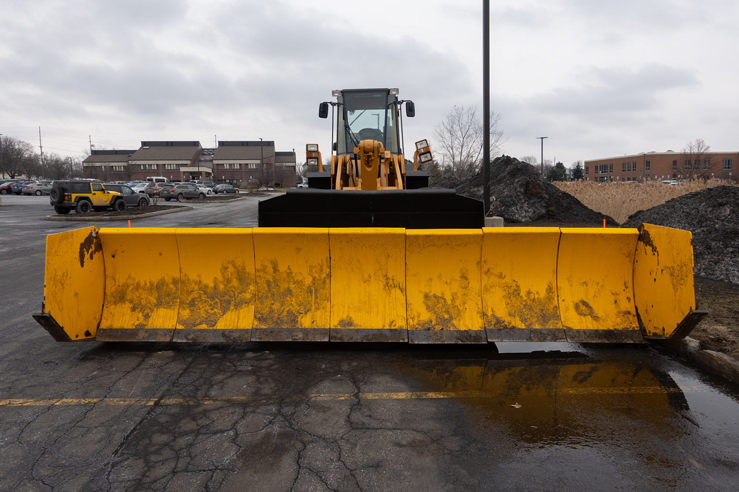 Yellow snow plow in parking lot. Rochester, New York