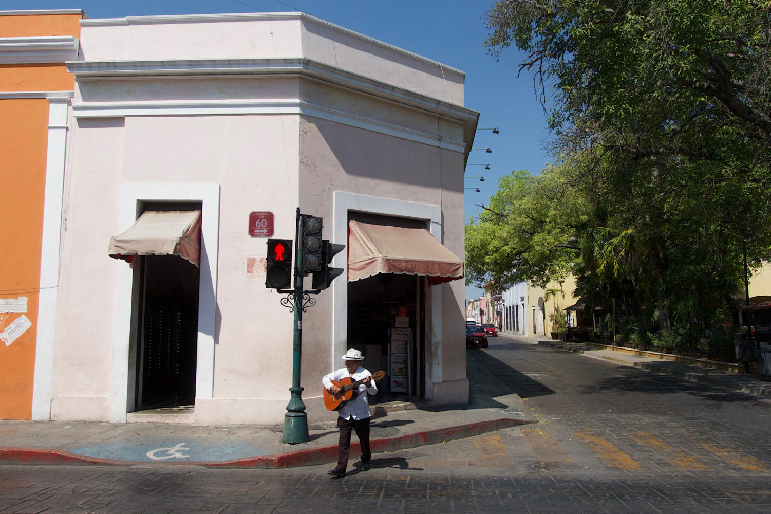 Musician crossing against the light in Merida