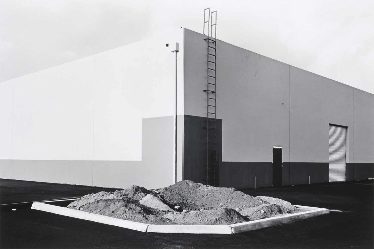 "South Corner, Riccar America Company, 3184 Pullman, Costa Mesa" (1974) by the American photographer Lewis Baltz from "New Topographics: Photographs of a Man-Altered Landscape" Eastman Museum 1975