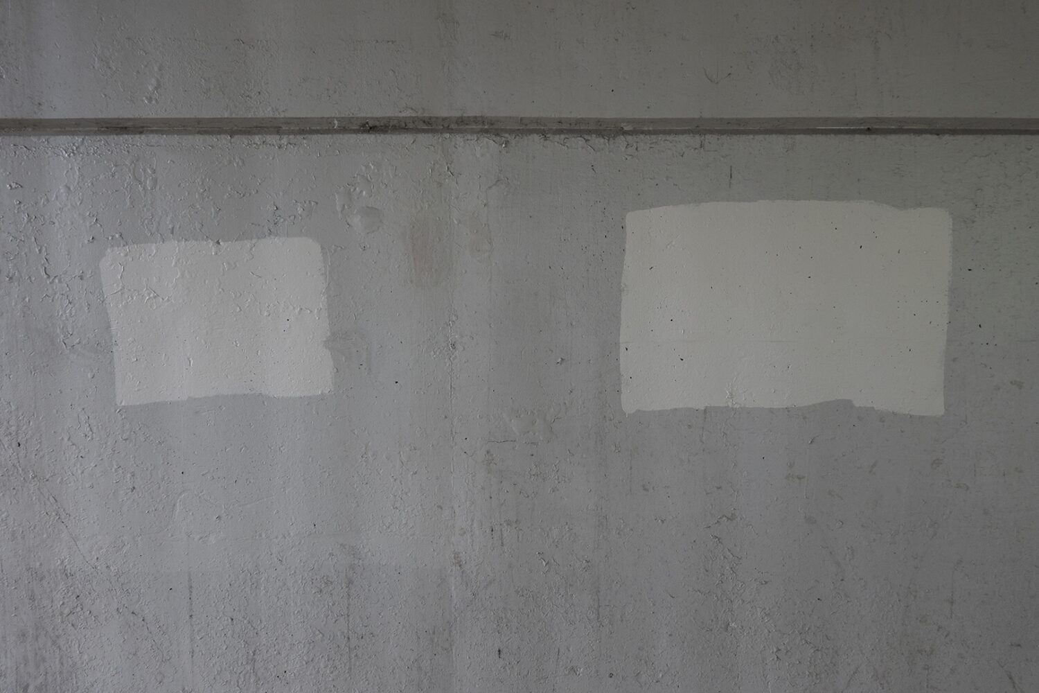 Graffiti cover-up paint on wall under expressway downtown